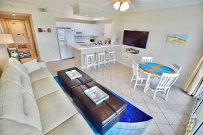 Una sala moderna con un sofá, una mesa de centro y un comedor con una mesa y sillas.