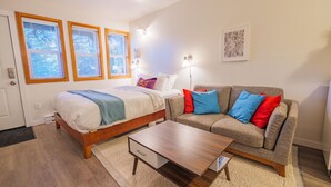 Un dormitorio moderno con cama, sofá y una mesita de centro.