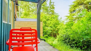 Un espacio al aire libre cubierto con una silla roja y una valla de madera.