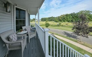 Relax on the porch with a view of the surrounding greenery and neighborhood street.