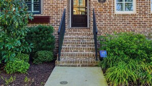 A brick building with a front door, a small porch, and a mailbox. - Watch Cargo Ships Glide by from This Walkable Savannah River Retreat (Savannah)