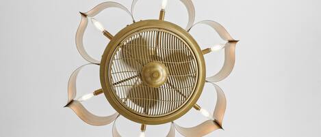 Ein Deckenventilator mit zentraler Beleuchtung und einem dekorativen, symmetrischen Design.