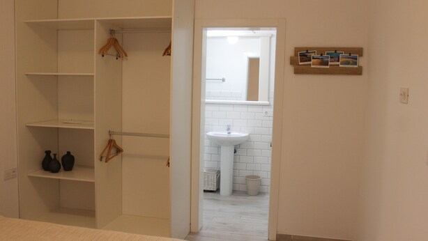 A bedroom with a bed, a wardrobe with hanging space, and a bathroom visible through an open door. - MAXORATA TOWN FUERTEVENTURA (Morro Jable)
