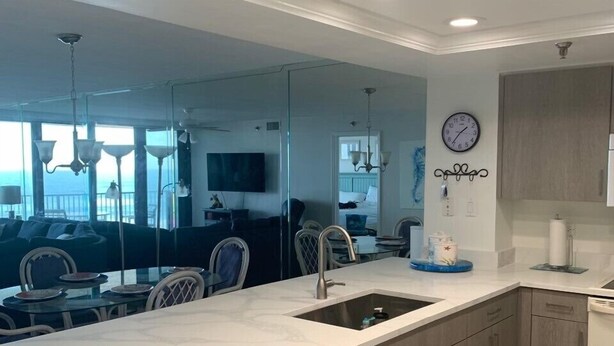 Una cocina moderna con una isla grande, electrodomésticos integrados y vistas al área de estar.
