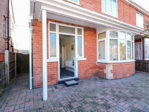 A red brick house with a white-framed front door, a small porch, and a paved driveway. - 4 Dorothy Avenue (Skegness)