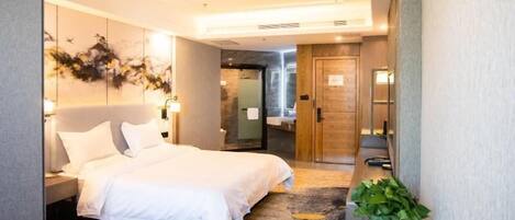 Una habitación de hotel moderna con una cama grande, un escritorio y una planta en maceta.