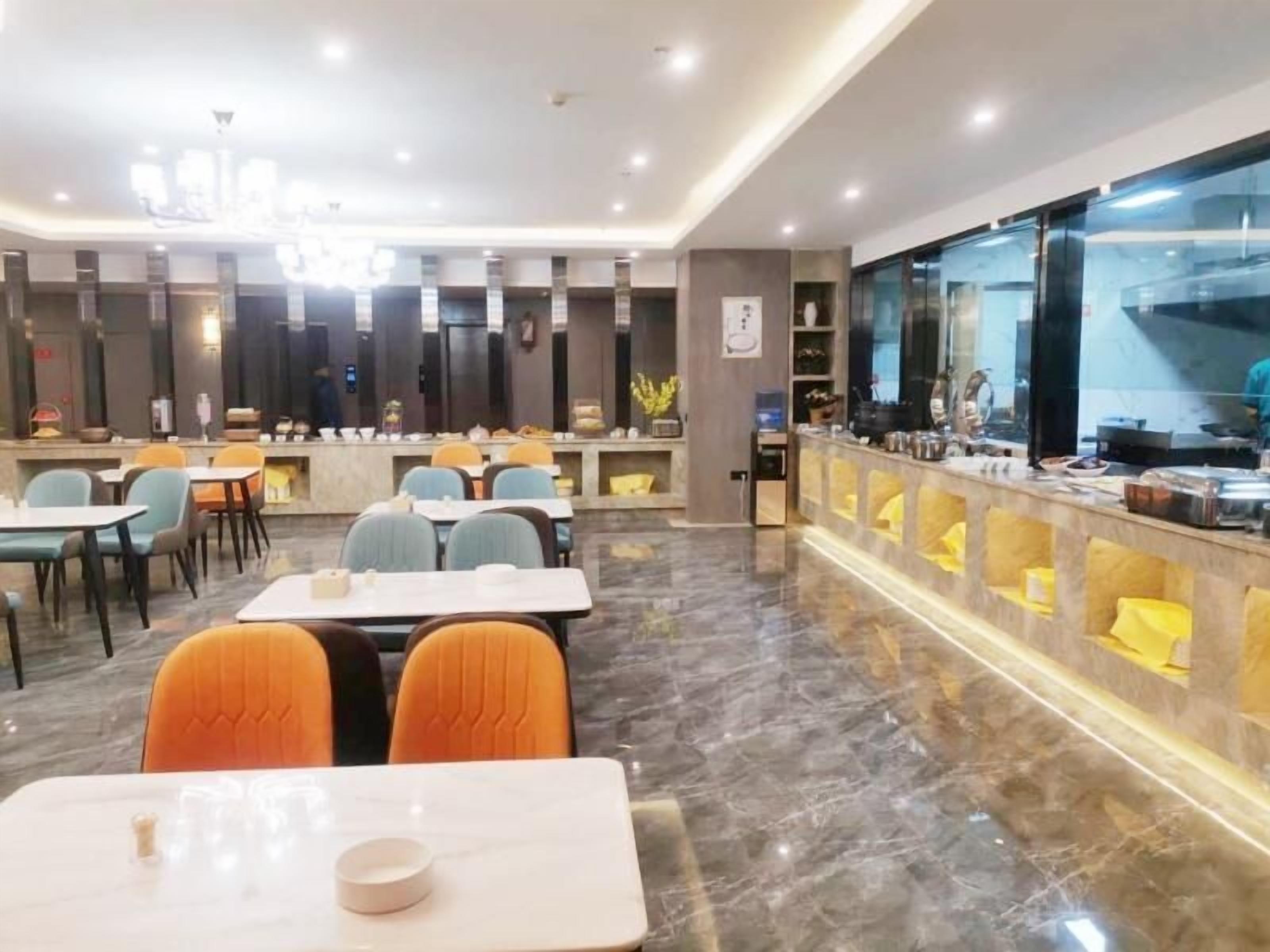 A hotel dining area with tables and chairs, a buffet counter, and a large window.