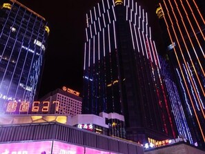 Um edifício moderno com faixas verticais de luz e sinalização.
