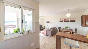 A modern living room with a dining area, large windows, and a view of the city. - Apartment in Okrug Gornji with Seaview, Terrace, Air condition, WIFI (5051-2) (Okrug Gornji)