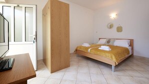 A bedroom with a bed, a desk, and a wardrobe.