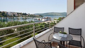 A balcony with a table and chairs overlooking a marina with boats and a lake. - Apartment in Seget Vranjica with Seaview, Balcony, Air condition, WIFI (5052-3) (Seget Vranjica)