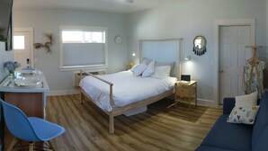 Une chambre à coucher comprenant un lit, un bureau avec une chaise, une commode, une table de chevet avec une lampe, une horloge et une porte.