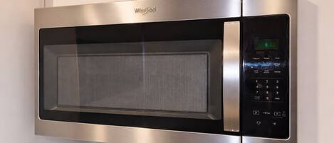 Un four à micro-ondes Whirlpool en acier inoxydable, doté d’un écran numérique, d’un panneau de commande et d’un plateau tournant en verre.
