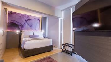 Une chambre à coucher moderne avec un lit, une télévision et un mur en marbre.