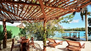 Een buitenruimte met houten meubels en een pergola.