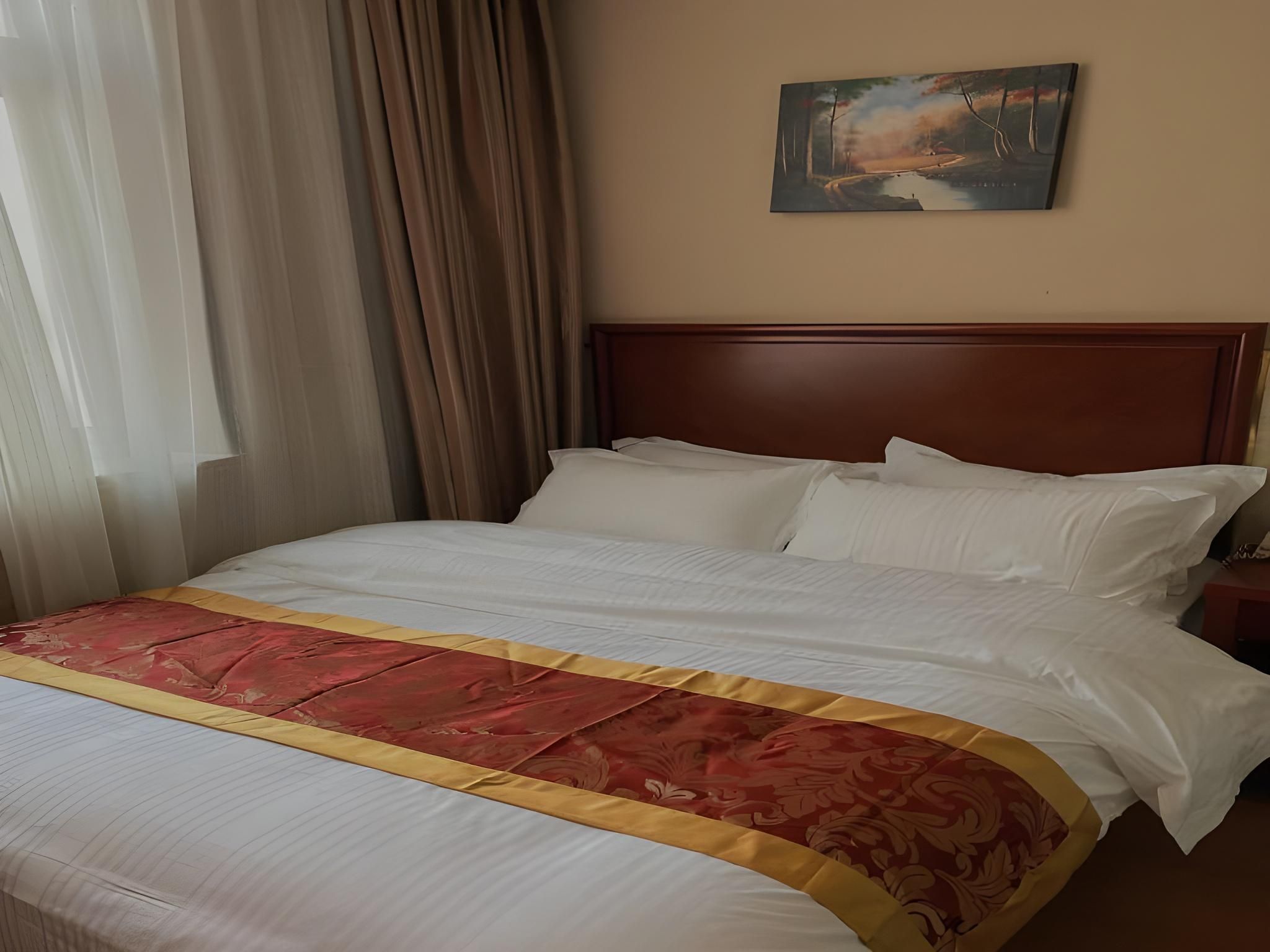 Quarto de hotel com uma cama grande, cabeceira de madeira e um quadro na parede.