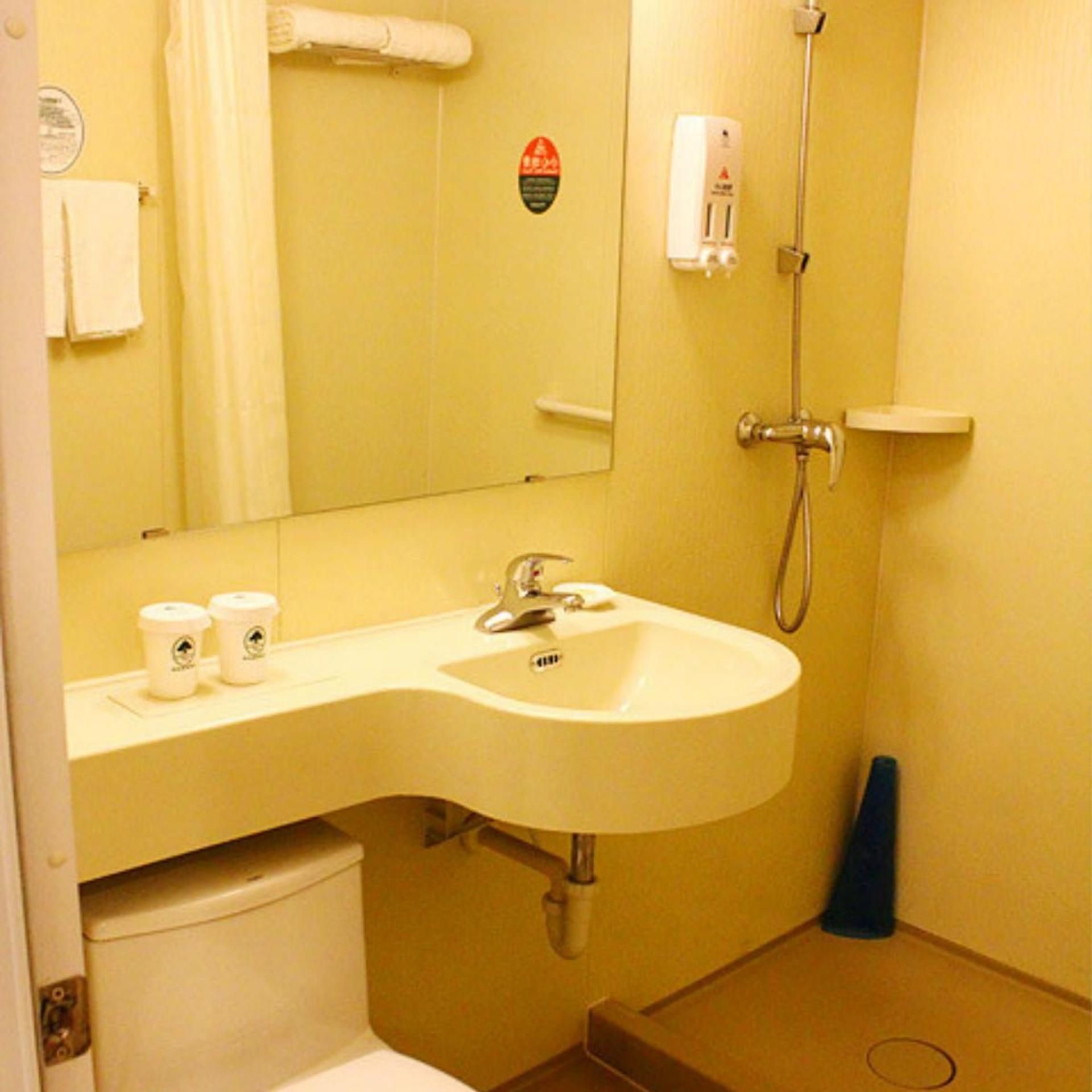 A bathroom with a sink, mirror, towel rack, and a shower.