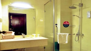 A bathroom with a glass-enclosed shower, a sink with toiletries, and a mirror. - Greentree Inn Beijing Shunyi District New International Exhibition Express Hotel (Beijing)