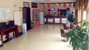 A hotel lobby with a reception desk, seating area, and a large plant. - Greentree Inn Beijing Shunyi District New International Exhibition Express Hotel (Beijing)