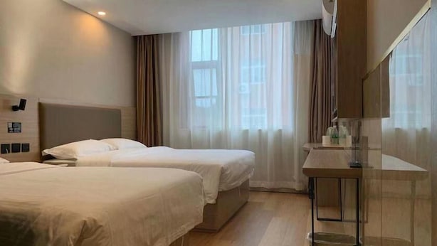 A hotel room with two beds, a small table, and a mirror. - Greentree Inn Beijing Shunyi District New International Exhibition Express Hotel (Beijing)
