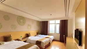 Une chambre d’hôtel avec deux lits, une télévision et une grande fenêtre.