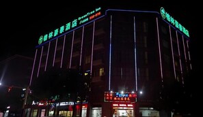 A hotel with illuminated signage, a prominent entrance, and multiple windows.