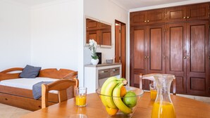 Ein Schlafzimmer mit einem hölzernen Bett, einem Nachttisch, einer Obstschale und einem Glas Orangensaft.
