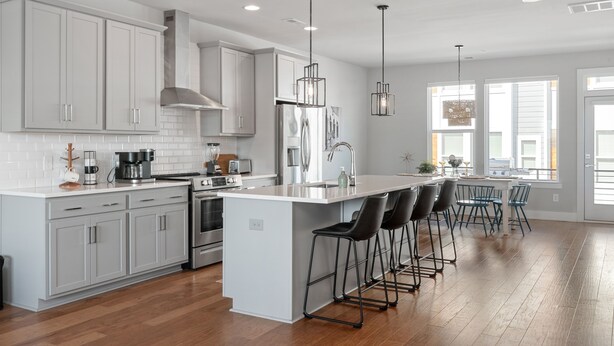A modern kitchen with white cabinets, stainless steel appliances, and a central island with bar stools. - Ultimate Downtown Charlotte Oasis, 10 Guests (Charlotte)