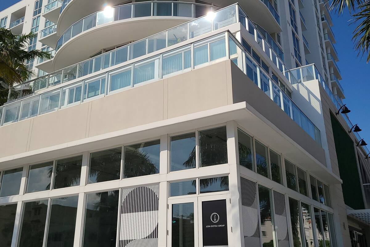 A modern multi-story building with a curved facade, large windows, and a glass entrance.