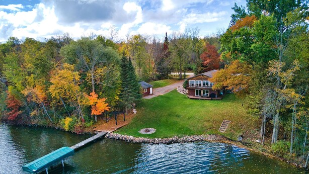Ein Haus mit gepflegtem Rasen und Steg direkt am See.