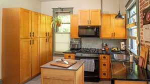 A kitchen with wooden cabinets, a microwave, a stove, and a sink.