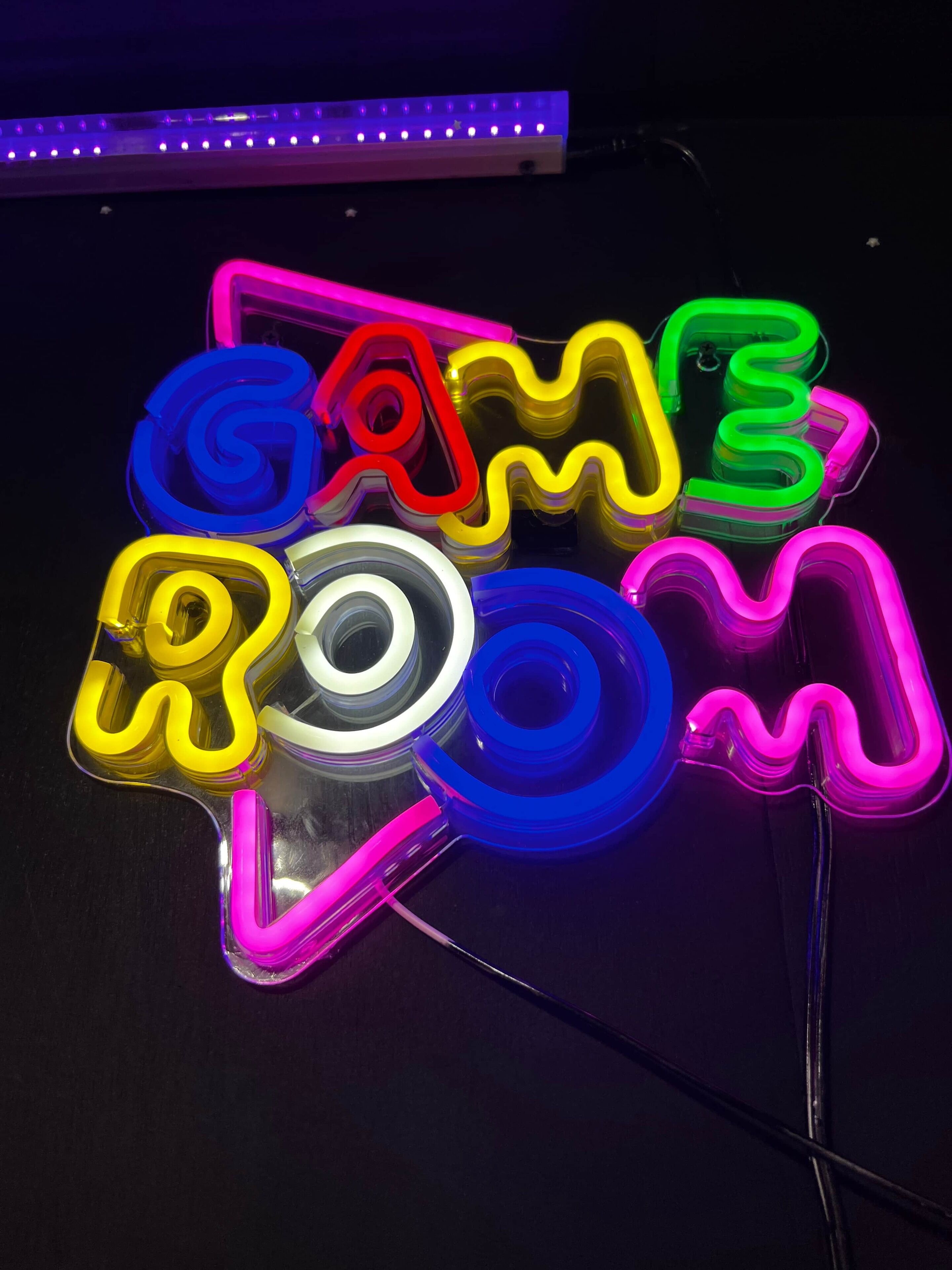 A neon sign with the word "GAMING" in colorful, wavy letters.