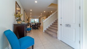 A hallway with a dining area, a staircase, and a door with a Star Wars decal. - Amazing Home With Spa & Games Room In Gated Resort Close to WDW (Kissimmee)