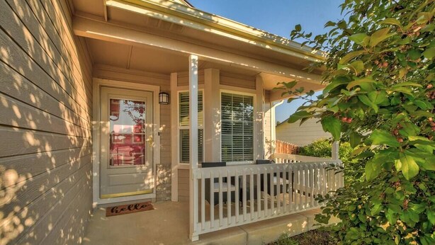 A house with a front porch, a door with a glass panel, and a small garden area with rocks and plants. - 4 BED/2 BATH; Sleeps 10! CO Springs- fenced yard, pets w/fee, Great for Families (Colorado Springs)