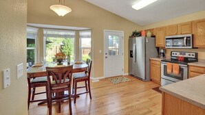 A kitchen with wooden cabinets, a stainless steel refrigerator, a microwave, and an oven. - 4 BED/2 BATH; Sleeps 10! CO Springs- fenced yard, pets w/fee, Great for Families (Colorado Springs)