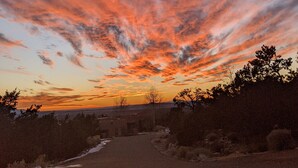 A sunset over a rural landscape with a dirt road leading into the distance. - Studio apartment 15 minute walk to the plaza (Santa Fe)