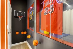 A basketball-themed room with a basketball hoop, a jersey with the number 23, and four basketballs mounted on the wall. - 3159- Great Family Home near Disney, private pool, Storey Lake Resort. (Kissimmee)