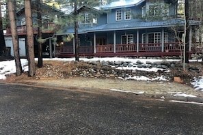 A two-story house with a porch, stone foundation, and a metal roof. - HAKUNA MATATA  (South Lake Tahoe)