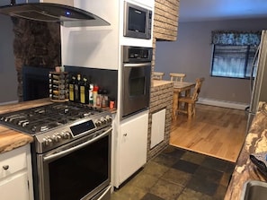 Enjoy cooking in this well-equipped kitchen with a central island, stainless steel stove, and oven.