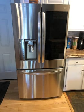 Kitchen features a stainless steel refrigerator with a water and ice dispenser, a dishwasher, and a coffee maker.