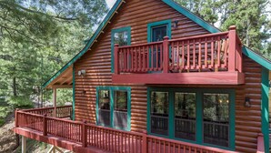A two-story log cabin with a balcony and multiple windows. - The Gracia Inn-Luxury Cabin amidst Ponderosa Pines (Flagstaff)