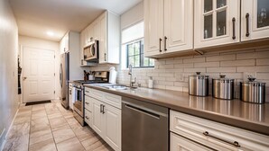 A kitchen with white cabinets, stainless steel appliances, and a tiled backsplash. - The Gracia Inn-Luxury Cabin amidst Ponderosa Pines (Flagstaff)
