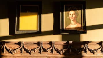 Two framed artworks on a wall with intricate wooden carvings below.
