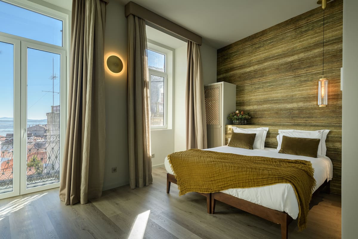Ein modernes Schlafzimmer mit einem großen Bett, Blick auf die Stadt und einer Wand mit Holzverkleidung.