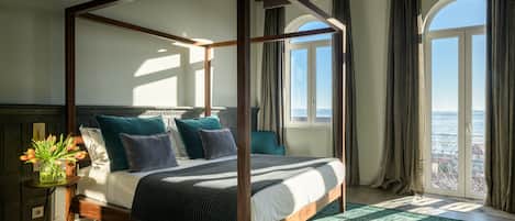 A four-poster bed with a view of the city through large windows.