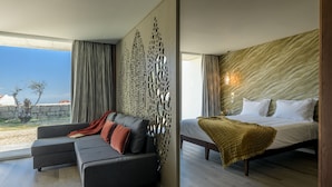A modern bedroom with a bed, a sofa, and a view of the outdoors. - Pena D'Água Boutique Hotel & Villas  (Covilhã)