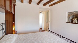 Un dormitori amb un llit, un armari de fusta i un quadre a la paret.