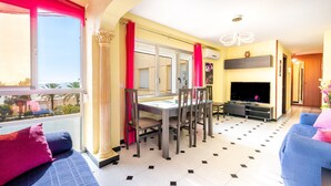 Un salon comprenant une table à manger, des chaises, un canapé, un téléviseur et une cheminée.