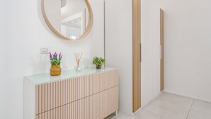Ein modernes Badezimmer mit einem Glas-Waschtisch, einem runden Spiegel und einem Holzschrank.