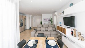 A modern apartment with a dining area, kitchen, and living space. - Luxury Apartment with shared swimming pool and jacuzi (Cómpeta)